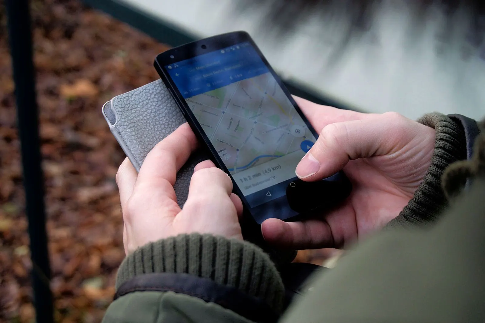 Close-up of two hands holding a smartphone showing Google Maps